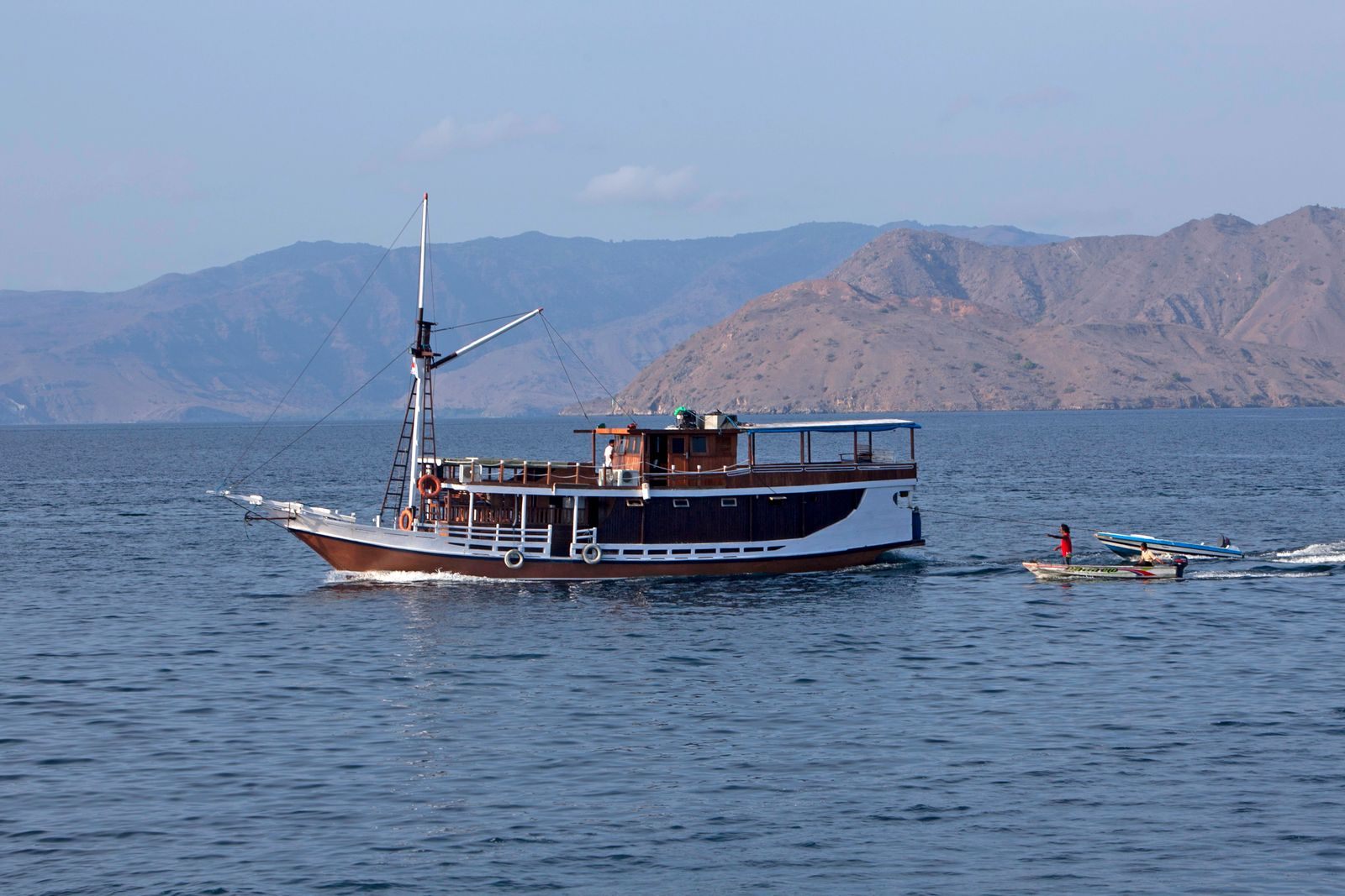Traditional wooden phinisi-style vessel near Komodo Island, the kind of craft behind small ship cruising in Indonesia