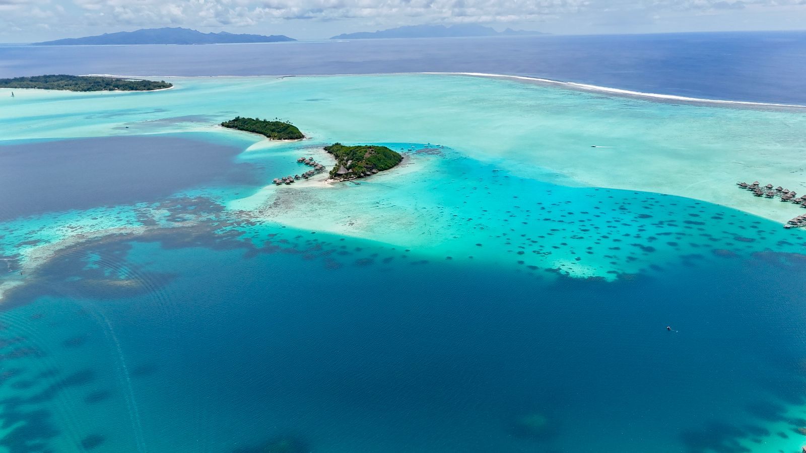 Aerial view of turquoise lagoon and small islets in French Polynesia, a classic route for small ship cruises in the South Pacific